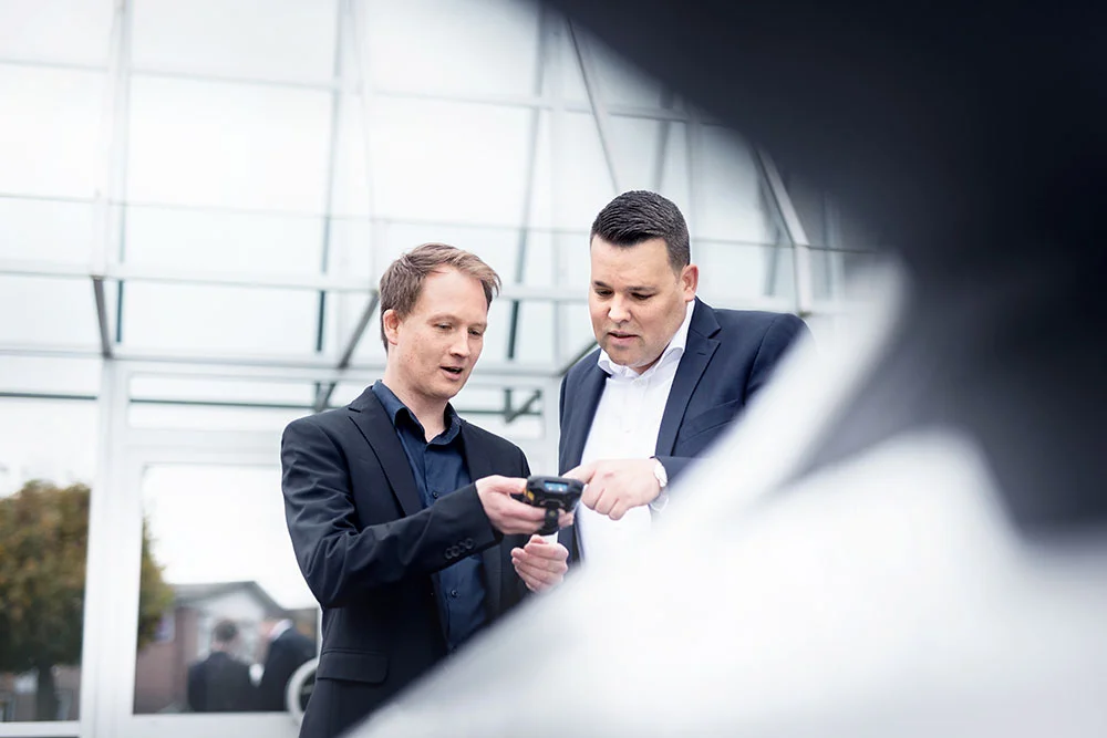 Zwei berufserfahrene Mediaform-Mitarbeiter mit einem MDE-Gerät zur mobilen Datenerfassung.