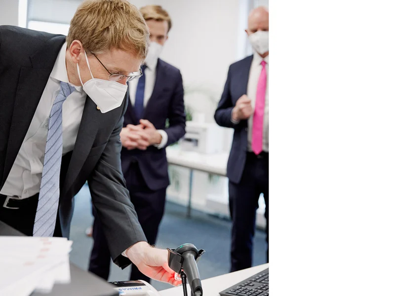 Ministerpräsident Daniel Günther scannt beim Besuch bei Mediaform einen Barcode